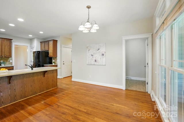 8008 Battersea Ct, Waxhaw, NC 28173 - kitchen with a sink, freestanding refrigerator, a breakfast bar area, and light wood-style flooring