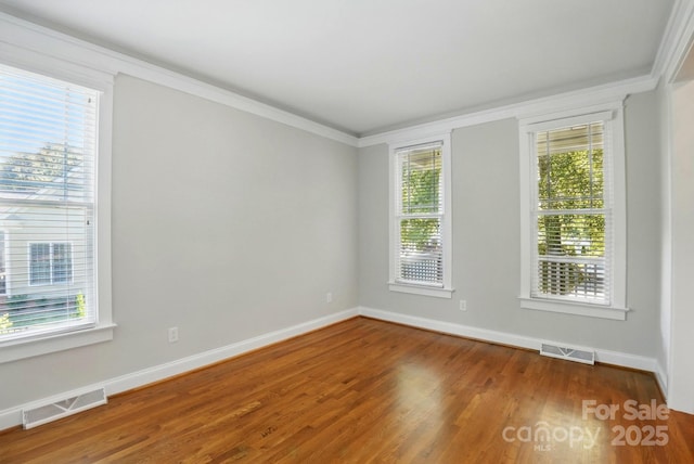 8008 Battersea Ct, Waxhaw, NC 28173 - spare room featuring baseboards, ornamental molding, wood finished floors, and visible vents