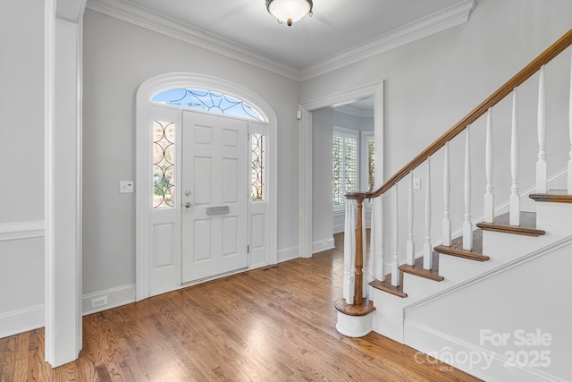 foyer featuring crown molding, stairway, wood finished floors, and baseboards