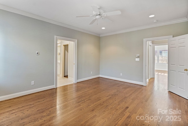 unfurnished room with baseboards, a ceiling fan, light wood-style flooring, and crown molding