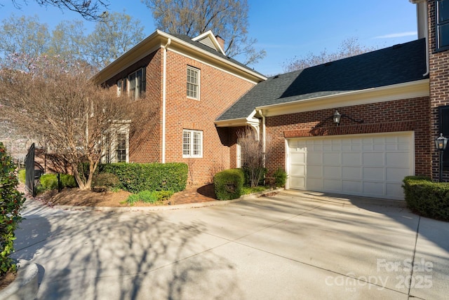 view of front of house featuring brick siding, a garage, and driveway