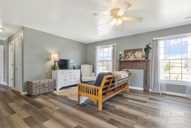 bedroom with ceiling fan, baseboards, and wood finished floors