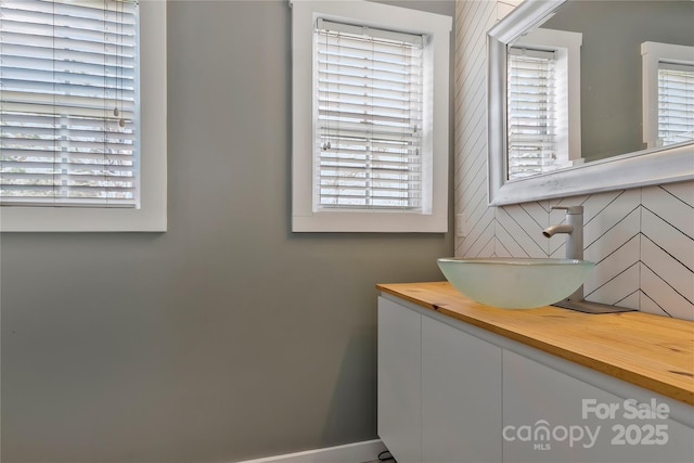 bathroom featuring plenty of natural light, baseboards, and vanity