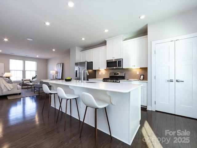 1814 Shumard Ln, Charlotte, NC 28205 - kitchen featuring a kitchen island with sink, a sink, appliances with stainless steel finishes, a kitchen bar, and open floor plan
