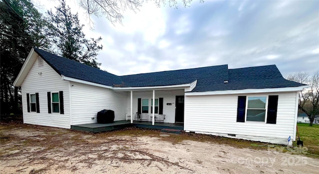 rear view of house with a shingled roof, a porch, and crawl space