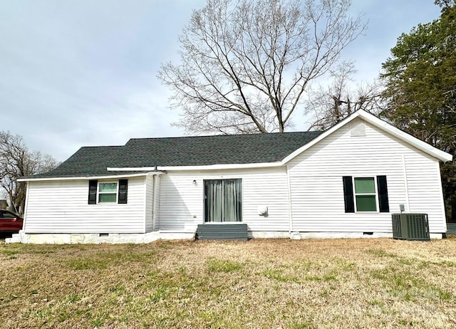 back of property featuring a shingled roof, cooling unit, a lawn, and crawl space