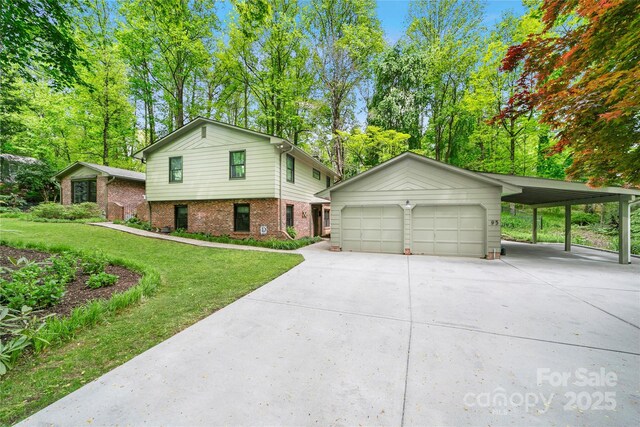95 Ridgewood Pl, Brevard, NC 28712 - view of front facade featuring a front yard, driveway, an outdoor structure, brick siding, and view of wooded area