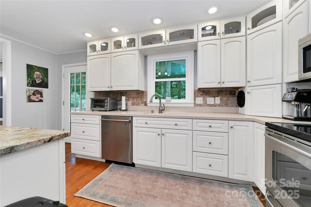95 Ridgewood Pl, Brevard, NC 28712 - kitchen with stainless steel appliances, backsplash, light wood-style flooring, ornamental molding, and a sink