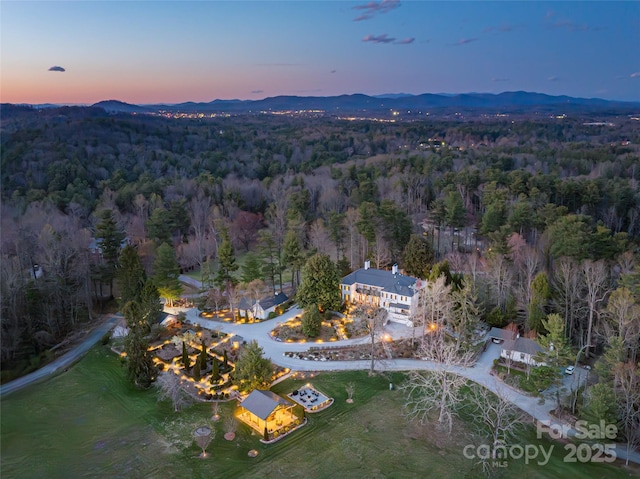 aerial view at dusk with a view of trees and a mountain view