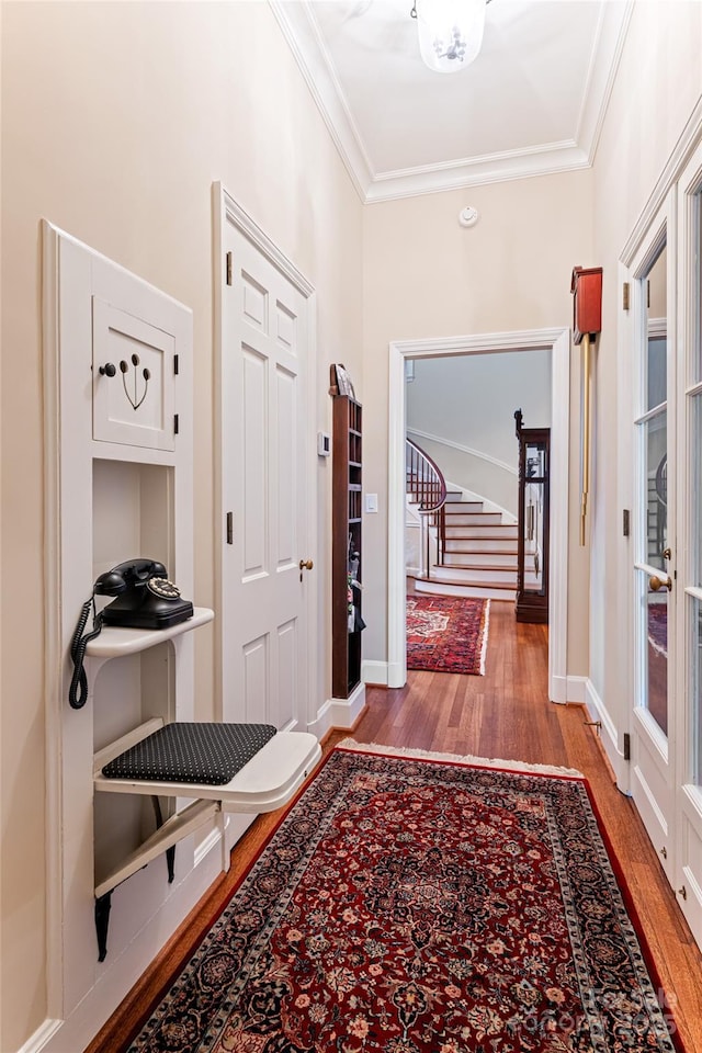hallway featuring stairway, crown molding, and wood finished floors