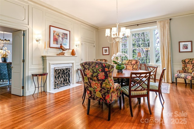 dining area featuring a decorative wall, a notable chandelier, and crown molding