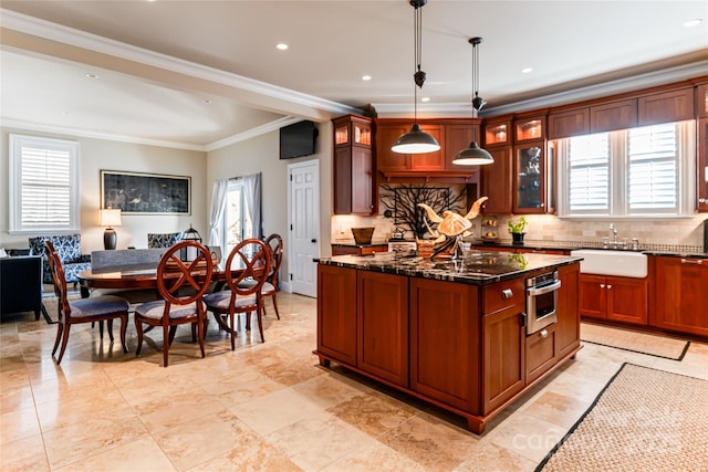 kitchen featuring tasteful backsplash, a sink, glass insert cabinets, and stainless steel oven