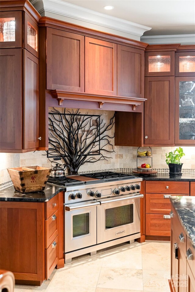 kitchen featuring crown molding, glass insert cabinets, range with two ovens, and tasteful backsplash
