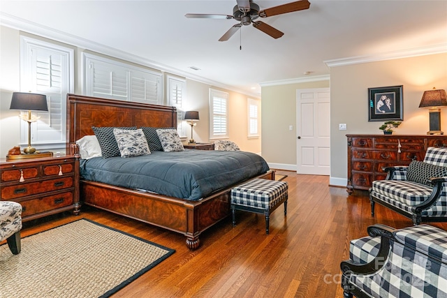 bedroom with visible vents, baseboards, a ceiling fan, crown molding, and wood finished floors