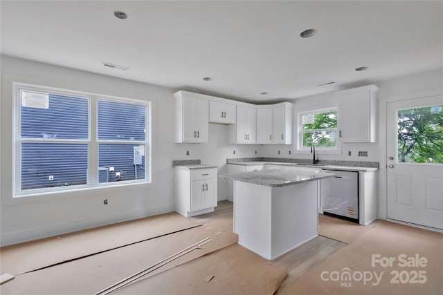 513 Harrel St, Salisbury, NC 28144 - kitchen featuring stainless steel dishwasher, light stone counters, white cabinets, a sink, and a kitchen island