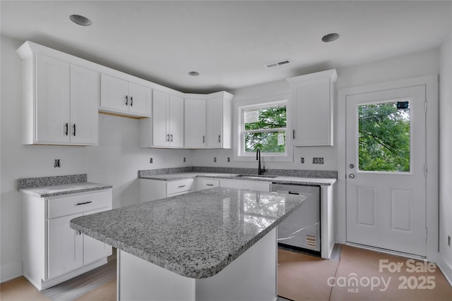 513 Harrel St, Salisbury, NC 28144 - kitchen with stainless steel dishwasher, a sink, light stone countertops, white cabinets, and a center island