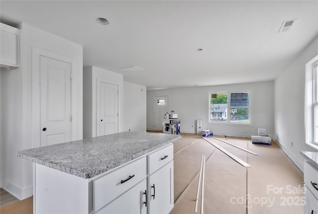 513 Harrel St, Salisbury, NC 28144 - kitchen featuring white cabinets, open floor plan, baseboards, and a kitchen island
