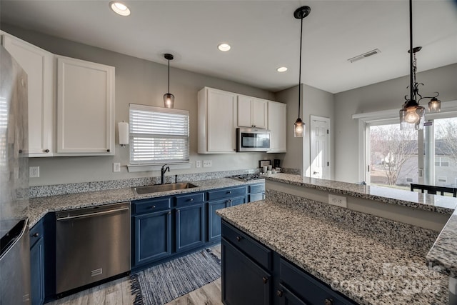 10071 Highland Creek Cir, Indian Land, SC 29707 - kitchen featuring light wood-type flooring, visible vents, appliances with stainless steel finishes, blue cabinets, and a sink
