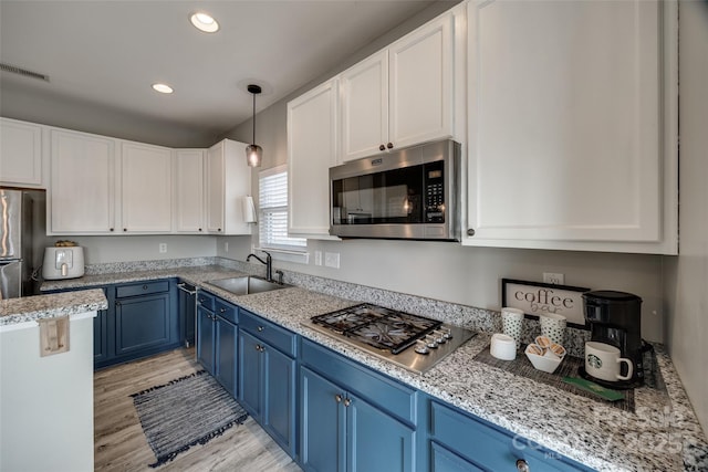 10071 Highland Creek Cir, Indian Land, SC 29707 - kitchen with blue cabinets, white cabinets, visible vents, appliances with stainless steel finishes, and a sink