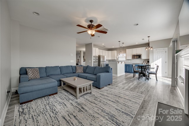 10071 Highland Creek Cir, Indian Land, SC 29707 - living area with ceiling fan with notable chandelier, light wood finished floors, baseboards, and visible vents