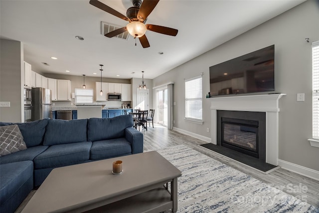 10071 Highland Creek Cir, Indian Land, SC 29707 - living room featuring baseboards, visible vents, light wood-type flooring, and a ceiling fan
