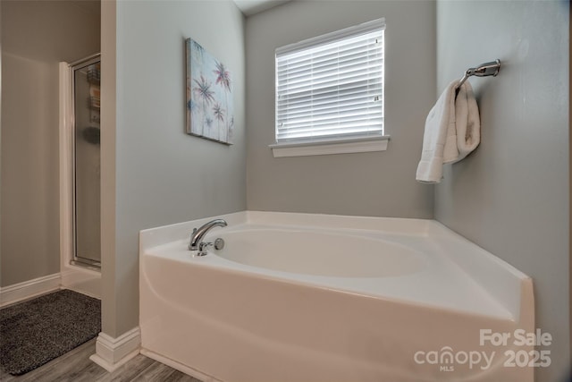 10071 Highland Creek Cir, Indian Land, SC 29707 - bathroom featuring a bath, a shower stall, and wood finished floors