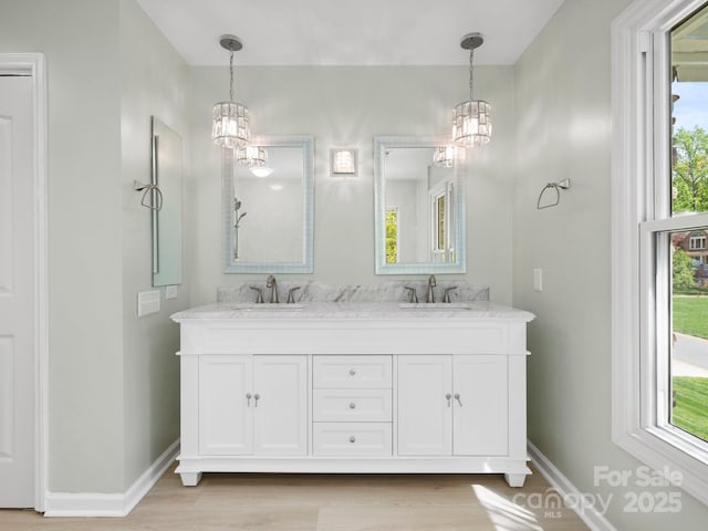 9009 Stourbridge Dr, Huntersville, NC 28078 - bathroom featuring a chandelier, baseboards, double vanity, and wood finished floors
