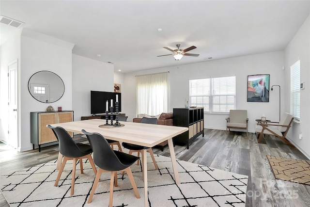 dining room with baseboards, visible vents, light wood-type flooring, and ceiling fan