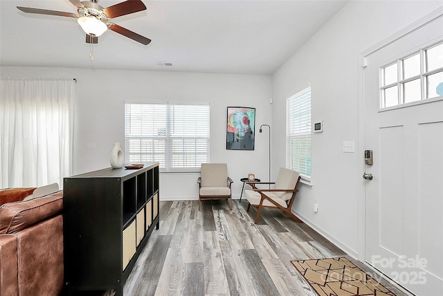 entrance foyer with a wealth of natural light, visible vents, wood finished floors, and a ceiling fan