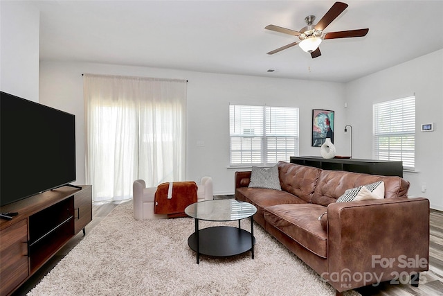 living room with wood finished floors and a ceiling fan
