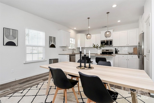 dining room featuring light wood finished floors, visible vents, recessed lighting, and baseboards