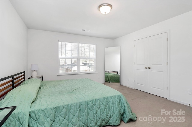 carpeted bedroom featuring baseboards and a closet