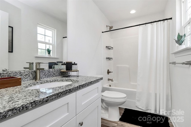 full bathroom with toilet, vanity, and shower / bath combo