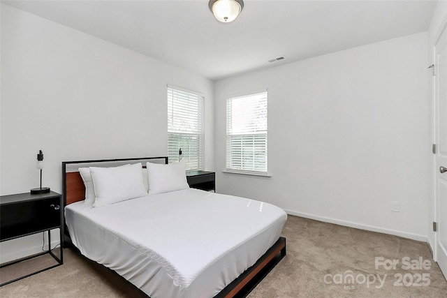 bedroom featuring visible vents, baseboards, and carpet