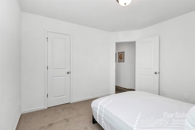 bedroom with baseboards and carpet
