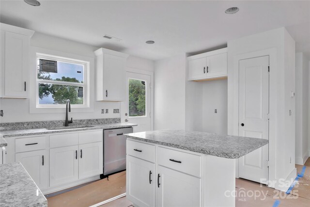 515 Harrel St, Salisbury, NC 28144 - kitchen featuring stainless steel dishwasher, a sink, white cabinets, a kitchen island, and light stone counters