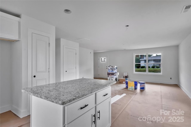 515 Harrel St, Salisbury, NC 28144 - kitchen with baseboards, white cabinets, a center island, and light stone countertops
