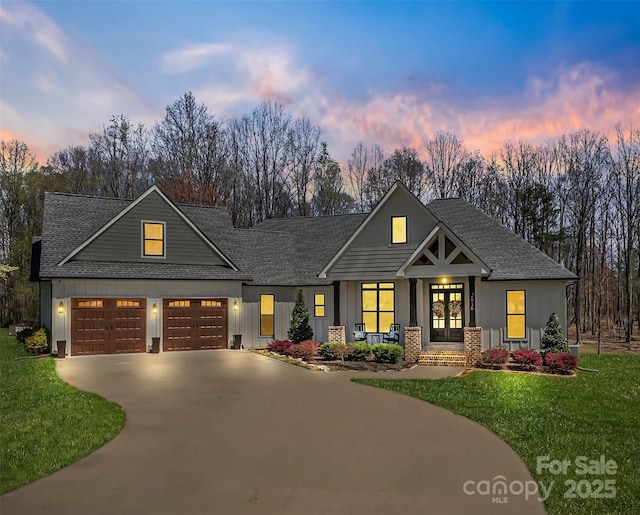 view of front of home with a front lawn, french doors, driveway, and board and batten siding