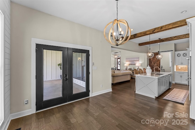 kitchen featuring a chandelier, dark wood finished floors, a sink, open floor plan, and french doors