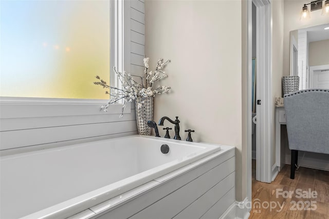 bathroom featuring a tub to relax in and wood finished floors