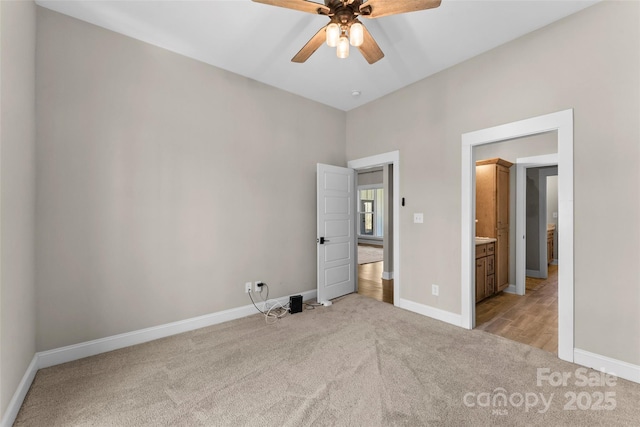 unfurnished bedroom with light colored carpet, ceiling fan, and baseboards