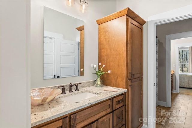 ensuite bathroom featuring ensuite bathroom, wood finished floors, and vanity