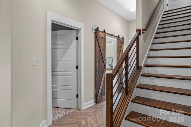 staircase with baseboards, a barn door, and recessed lighting