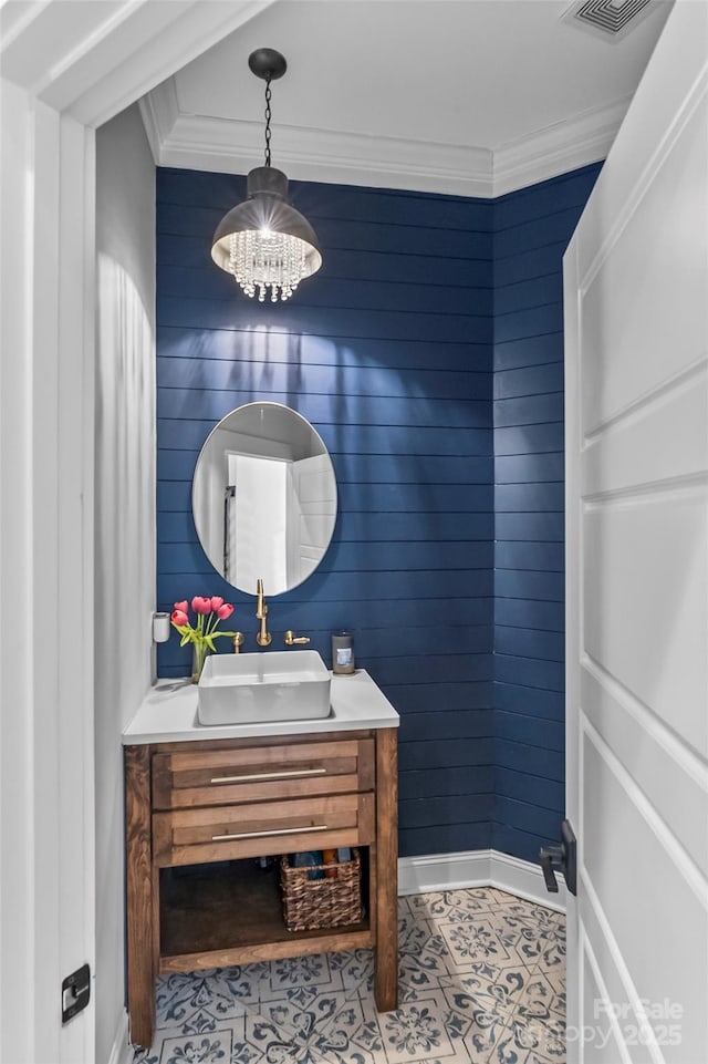 bathroom featuring vanity, crown molding, baseboards, visible vents, and a notable chandelier