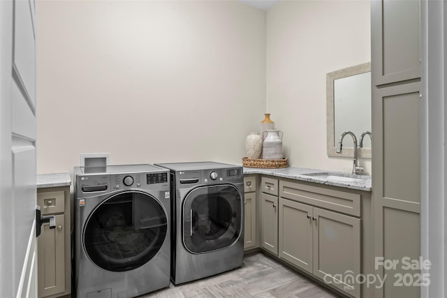 laundry room with a sink, cabinet space, and washer and dryer