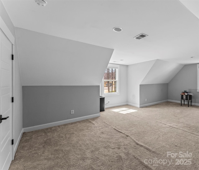 bonus room with carpet flooring, baseboards, vaulted ceiling, and visible vents