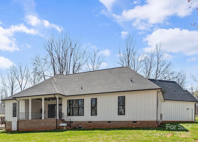 rear view of property featuring a sunroom, a shingled roof, crawl space, and a yard