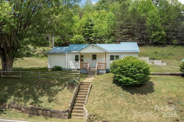 1022 Phipps Creek Rd, Burnsville, NC 28714 - view of front facade with covered porch, stairway, metal roof, and a view of trees