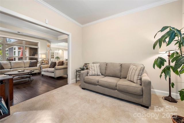 7909 Parknoll Dr, Huntersville, NC 28078 - living room featuring baseboards, ornamental molding, carpet flooring, wood finished floors, and a notable chandelier