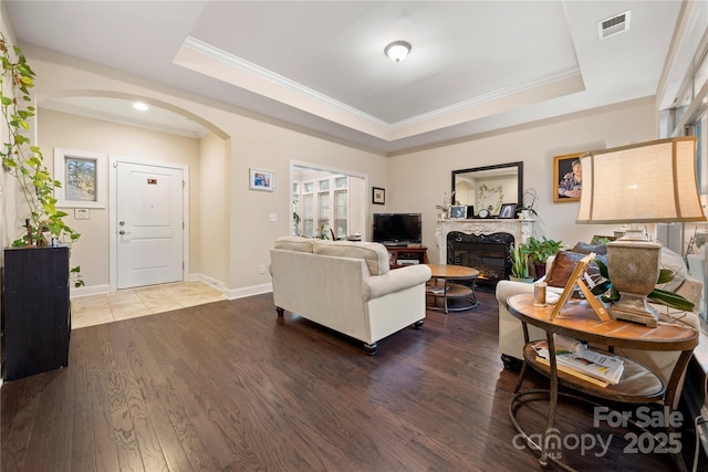 7909 Parknoll Dr, Huntersville, NC 28078 - living room with a fireplace, a tray ceiling, wood finished floors, and arched walkways